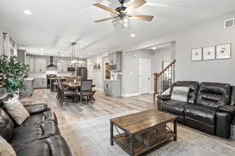 a view of a dining room with furniture a chandelier and wooden floor