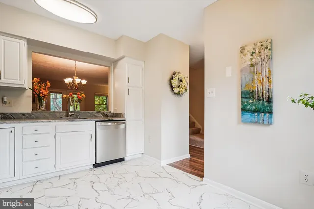 a view of a dining room with furniture a chandelier and wooden floor