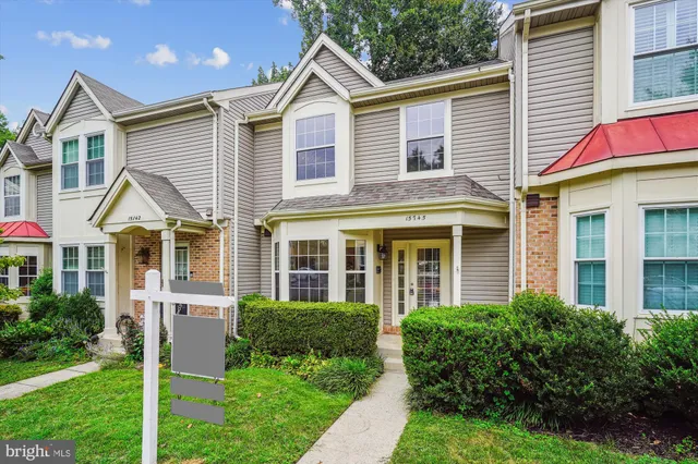 an aerial view of a houses with a lake and a yard