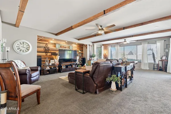 a living room with furniture kitchen view and a large window