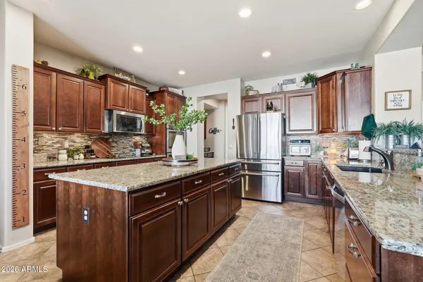 a kitchen with stainless steel appliances granite countertop a refrigerator and a stove top oven