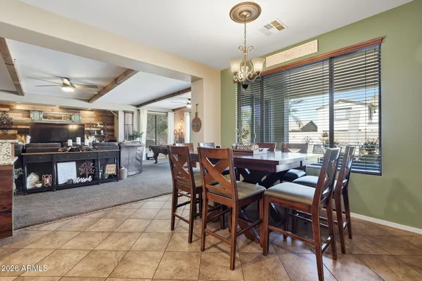 a kitchen with stainless steel appliances kitchen island granite countertop a refrigerator a stove a sink a dining table and chairs