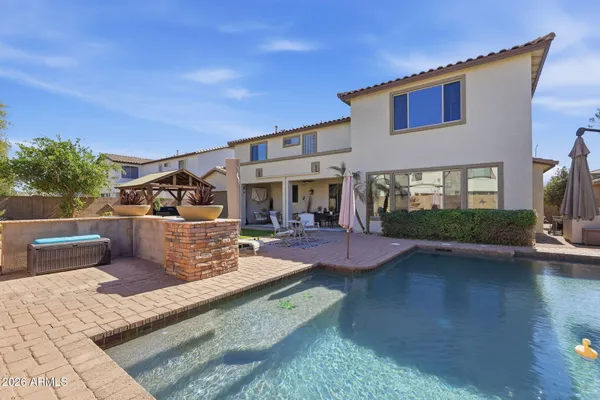 a view of a house with swimming pool and sitting area