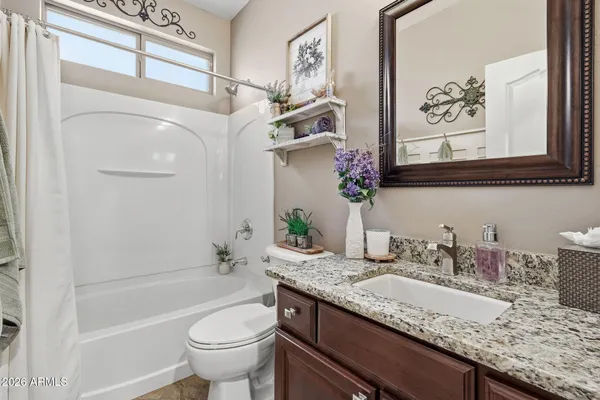 a bathroom with a granite countertop sink a toilet and a bathtub