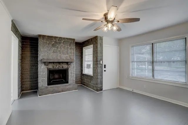 a view of an empty room with a fireplace and a window