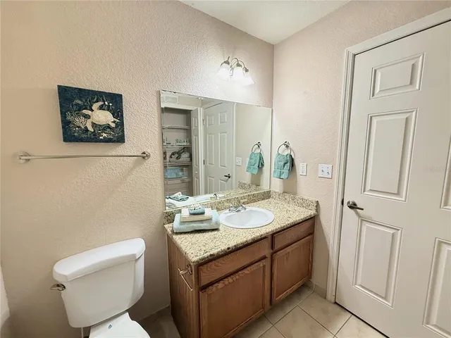 a bathroom with a granite countertop toilet sink and mirror