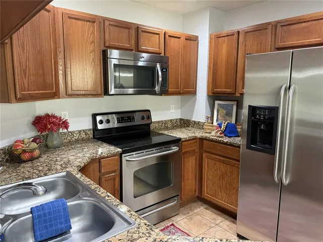 a kitchen with stainless steel appliances granite countertop a stove a microwave and a refrigerator