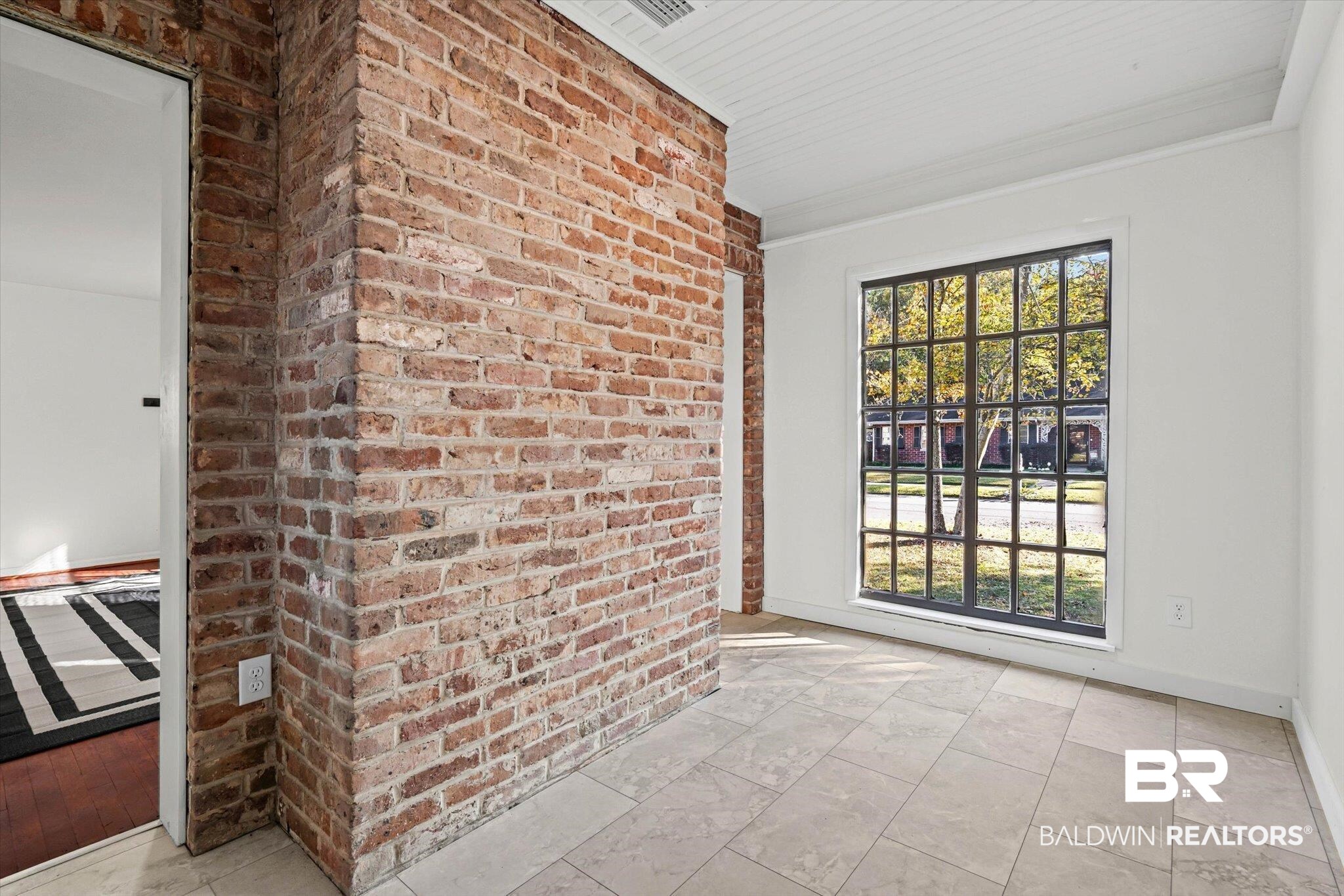 2806 Exter Drive Mobile, AL 36606 - Photo 6 of 24 Empty room with brick wall and ornamental molding