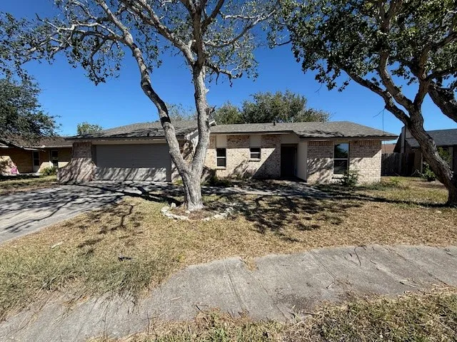 a view of a house with a yard from a large tree