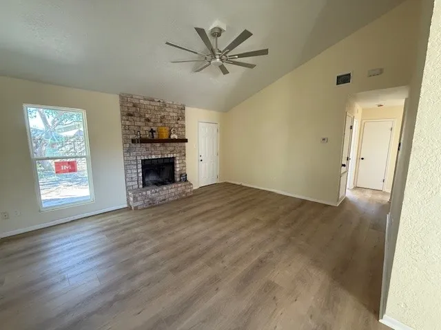 an empty room with windows and a fireplace