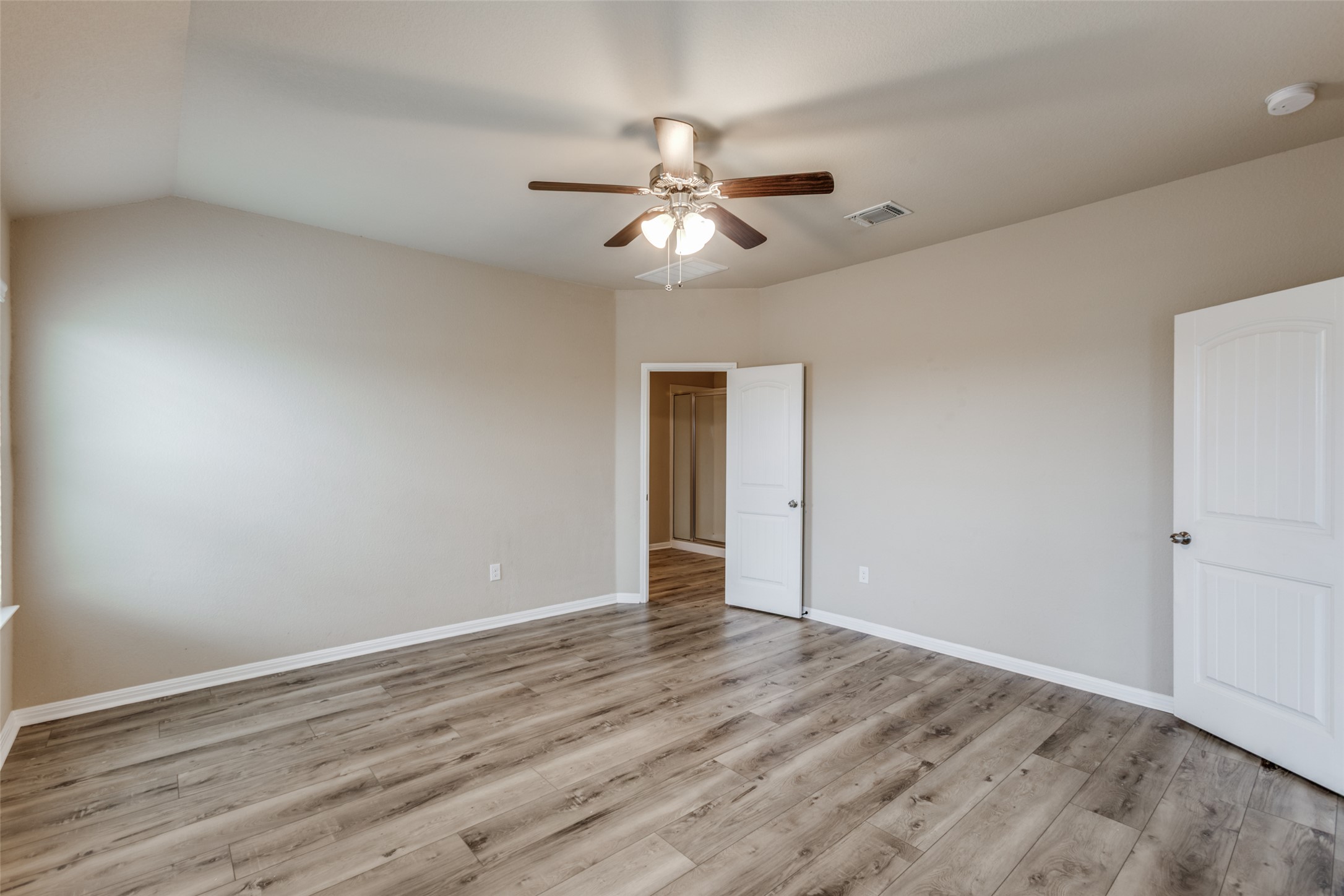 2909 Centrum Drive Austin, TX 78754 - Photo 18 of 30 Spacious room featuring vaulted ceilings, light-colored walls, wood-look flooring, and a ceiling fan