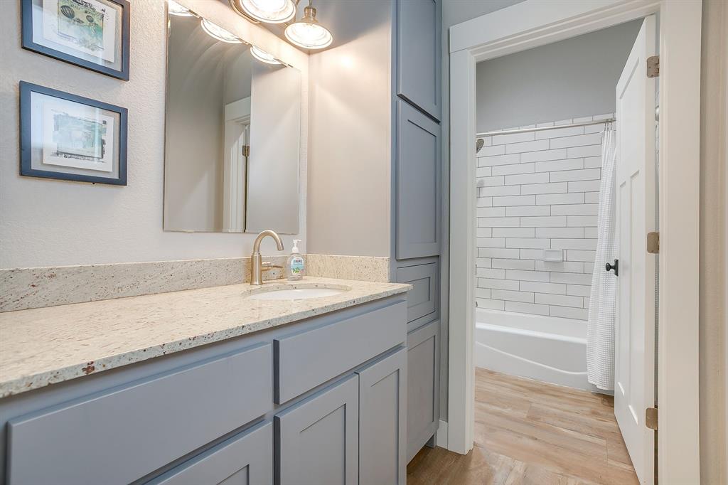 19611 North County Line Road Ponder, TX 76259 - Photo 26 of 40 a bathroom with a granite countertop sink a mirror and a