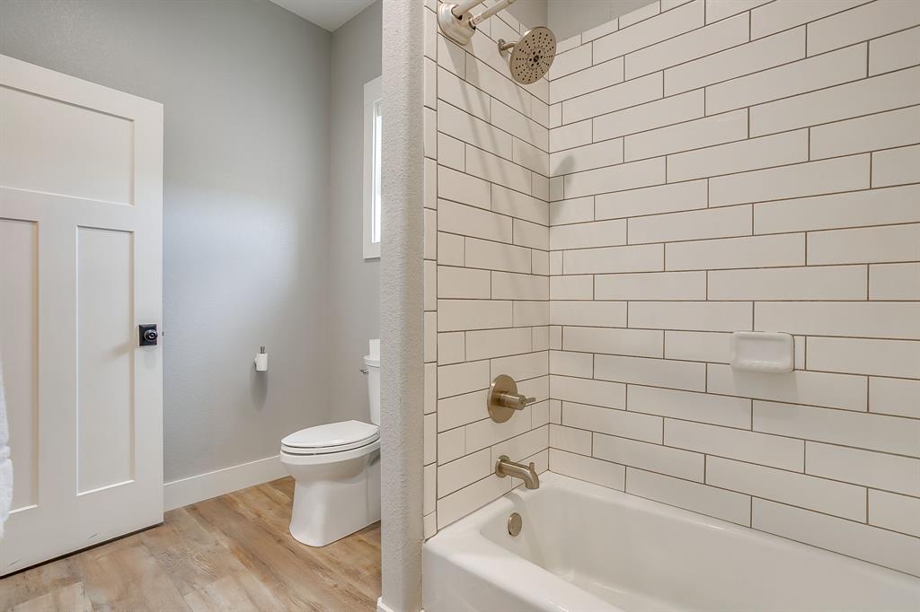 19611 North County Line Road Ponder, TX 76259 - Photo 27 of 40 a bathroom with a white toilet and a bathtub
