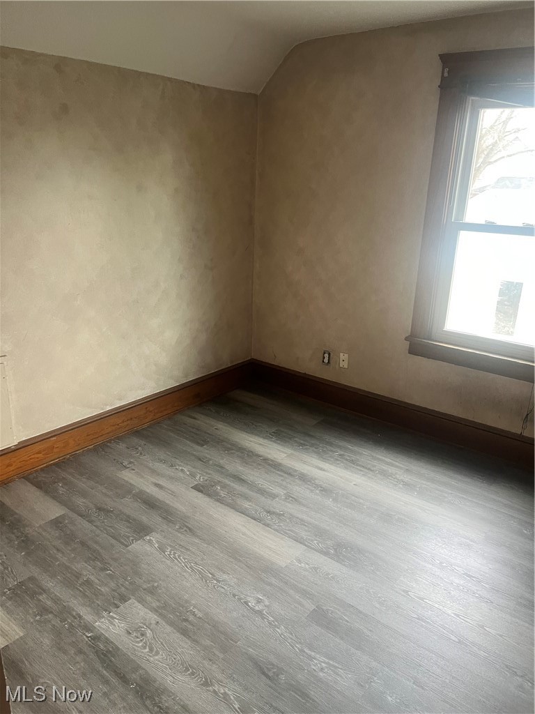 232 Selby Street Alliance, OH 44601 - Photo 14 of 15 Spare room with baseboards, vaulted ceiling, and wood finished floors