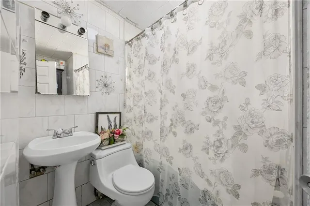 a bathroom with a sink a toilet and shower curtain