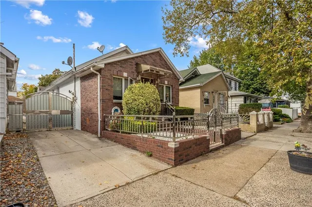 a view of a house with a fence in front of it