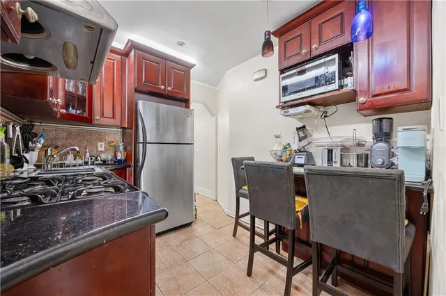 a kitchen with stainless steel appliances granite countertop a stove refrigerator and cabinets