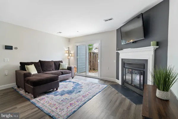 a living room with furniture a flat screen tv and a fireplace