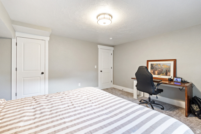 580 Cherry Ridge Lane Richmond, UT 84333 - Photo 43 of 53 Bedroom with light colored carpet, a desk, and a textured ceiling