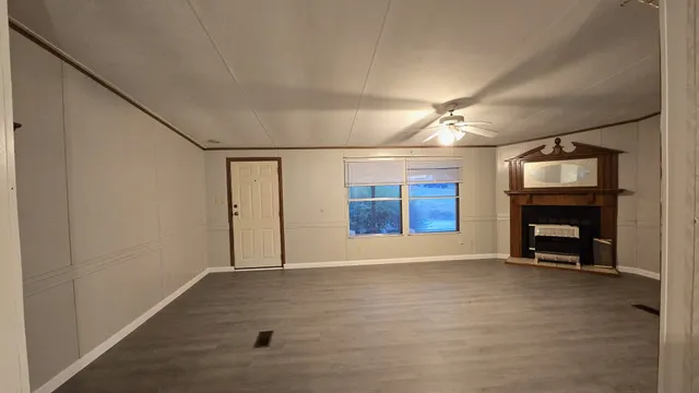 a view of an empty room with a window and fireplace