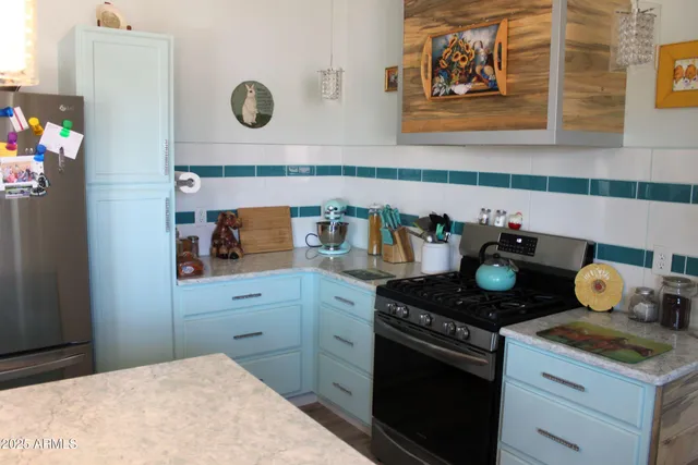 a kitchen with stainless steel appliances granite countertop a sink and a refrigerator