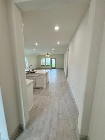 a view of a kitchen with a sink wooden floor and a refrigerator