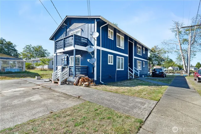 a view of a brick house with many windows next to a road