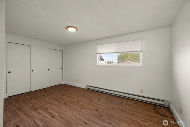 a view of empty room with wooden floor