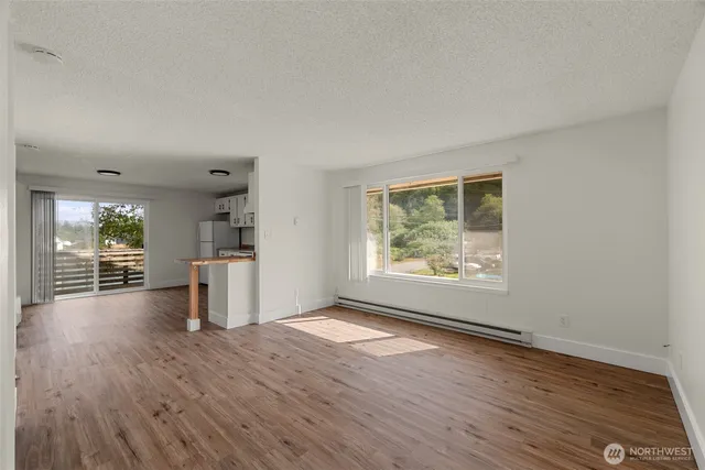 an empty room with wooden floor and windows