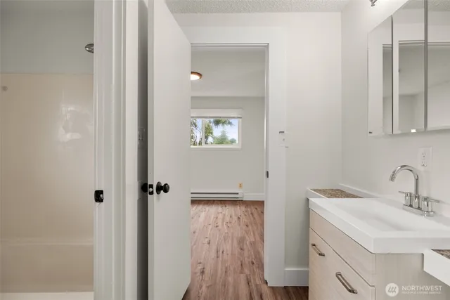 a bathroom with a sink a toilet and shower
