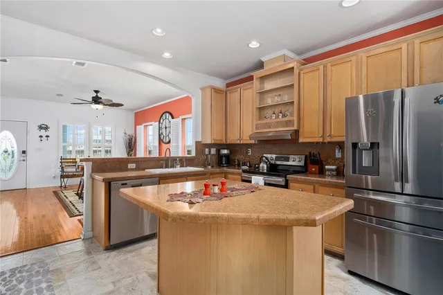 a kitchen with stainless steel appliances granite countertop a refrigerator a stove and a sink