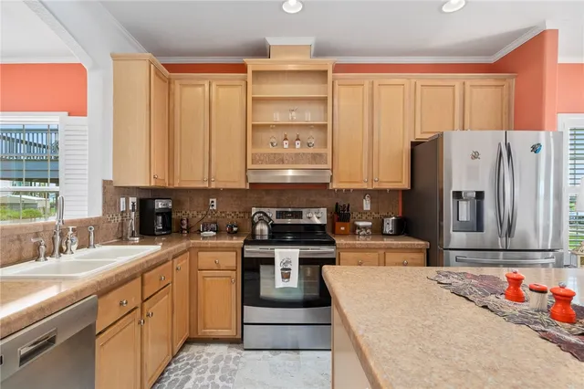 a kitchen with stainless steel appliances granite countertop a stove a sink and a refrigerator