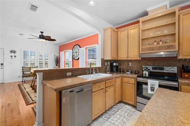 a kitchen with stainless steel appliances granite countertop a sink stove and cabinets