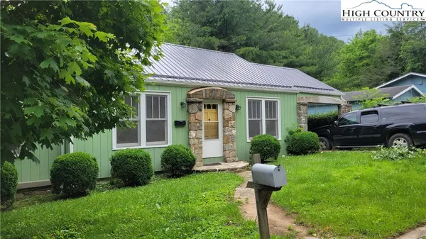 a front view of a house with garden and yard