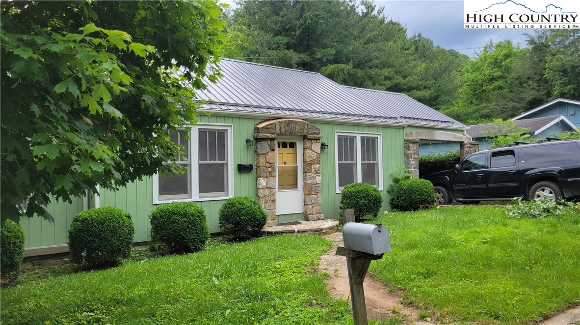 a front view of a house with garden and yard