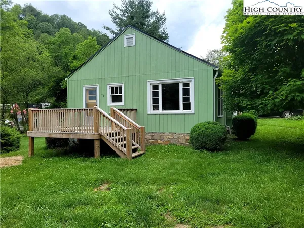 a view of a house with a yard and deck