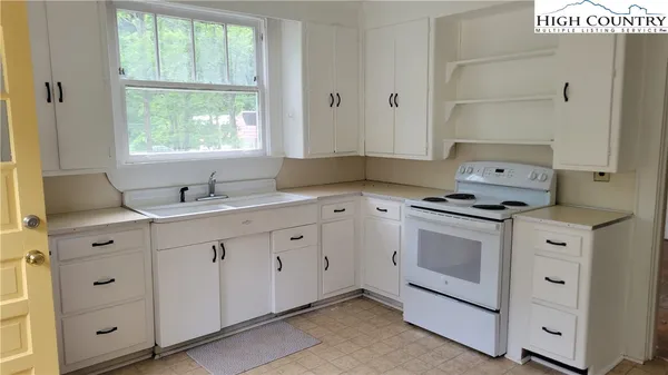 a kitchen with granite countertop white cabinets and white appliances