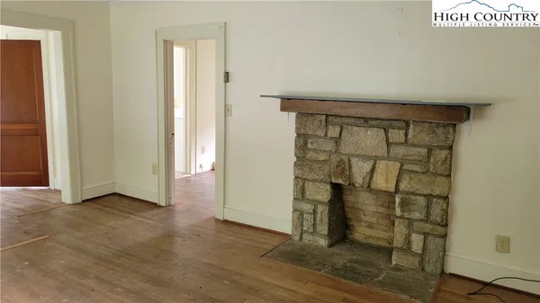 an empty room with wooden floor and cabinet