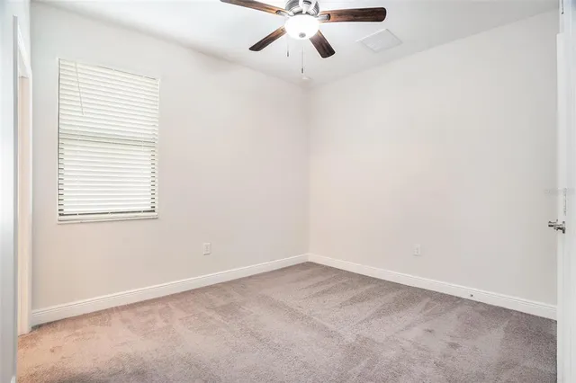 a view of an empty room with a ceiling fan