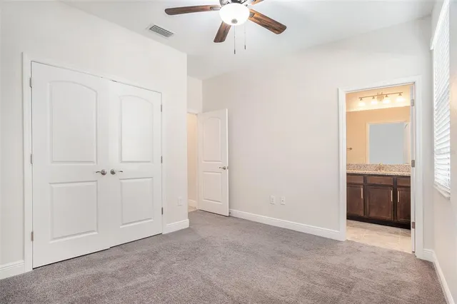 a bathroom with a granite countertop toilet sink and mirror