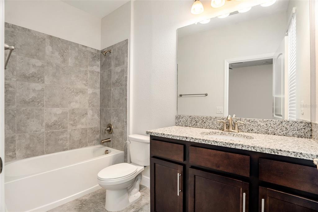12330 Newt Court New Port Richey, FL 34654 - Photo 21 of 30 a bathroom with a granite countertop toilet sink and mirror