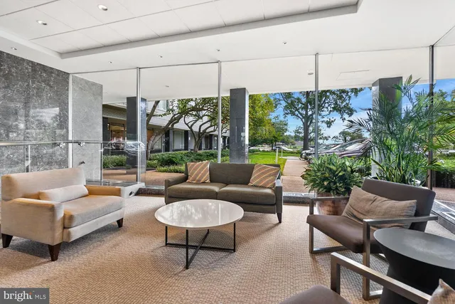 a living room with patio furniture and a potted plant