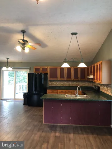 a kitchen with a wooden floor and a refrigerator