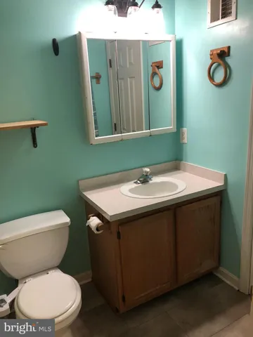 a bathroom with a toilet a sink and mirror