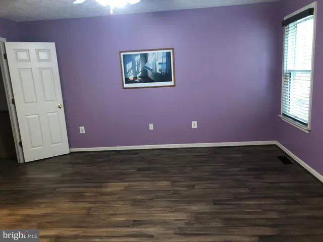 a view of room with window and wooden floor