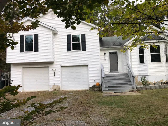 a view of a white house with large trees