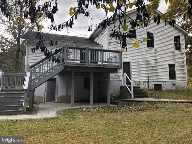 a view of a house with a small yard and large tree