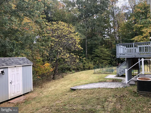 a view of roof deck with wooden fence and trees