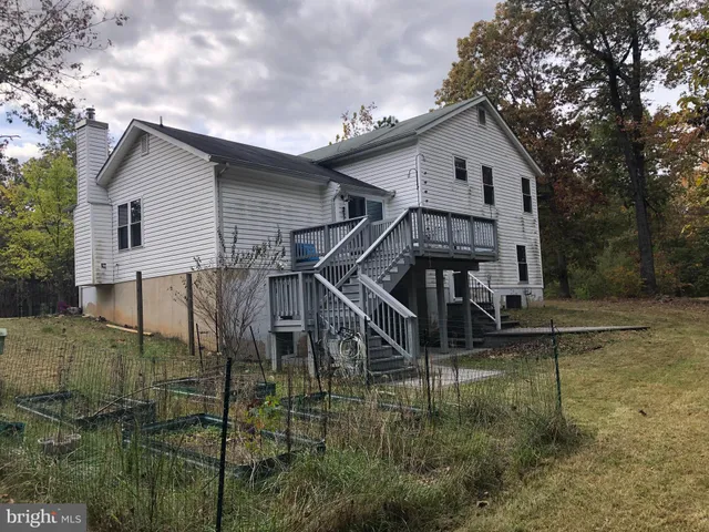 a white house that has a small yard and couches in it