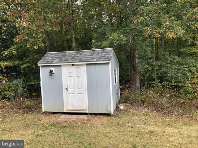 a view of a house with a tub and trees in the background